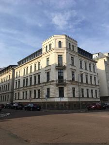 ein großes weißes Gebäude mit davor geparkt in der Unterkunft Parkside City Apartments No15 in Leipzig