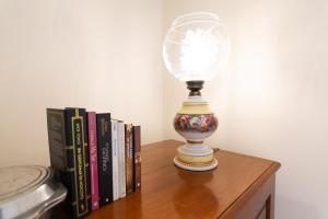 a lamp sitting on a table next to books at Suite 106 - Two bedroom apartment in Funchal