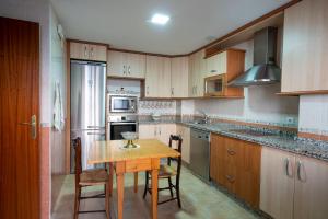 a kitchen with a wooden table and a small table with chairs at Casa Montesol in Cáceres