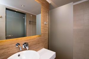 a bathroom with a sink and a mirror at Kallisti Hotel in Potos