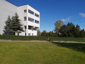 un edificio bianco con un cortile davanti di Pas Roma a Šventoji