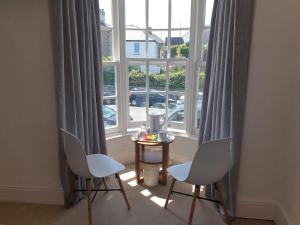 a room with two chairs and a table in front of a window at Bay Lodge in Penzance