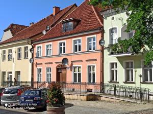 a row of houses with cars parked in front of them at Mieszkanie w Kamienicy in Pasłęk