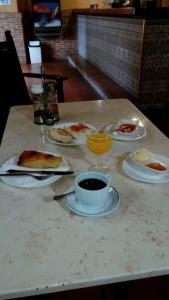 a table with plates of food and a cup of coffee at La Parra de Pepa in Cercedilla