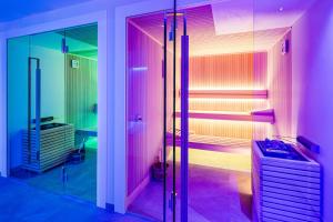 uma casa de banho com um chuveiro com luzes cor-de-rosa em Panorama Residence Saltauserhof Resort em Saltusio