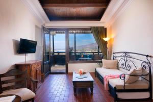 a living room with a bed and a large window at Kallisti Hotel in Potos