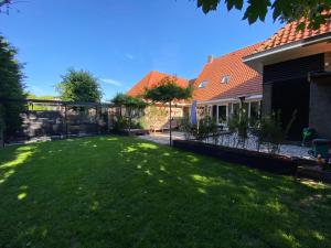 a yard with a fence and a house at De oude slaght- luxe suite met buitensauna in Zaandam