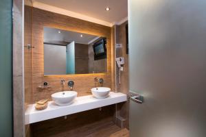 a bathroom with two sinks and a mirror at Kallisti Hotel in Potos