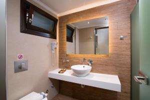 a bathroom with a sink and a mirror at Kallisti Hotel in Potos