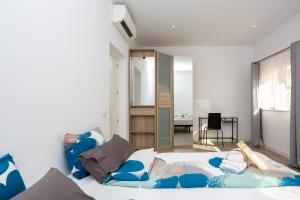a bedroom with a bed with blue and white pillows at Alma Suites Madrid CH in Madrid