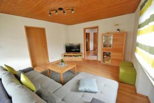 ein Wohnzimmer mit einem Sofa und einem Tisch in der Unterkunft Landhaus Christina in Rumbach