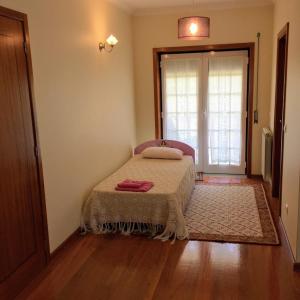 a bedroom with a bed and a door with a window at Casa do Reguengo in Arouca