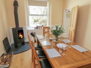 a dining room with a table with a wood stove at Pirate's Pad in St Austell