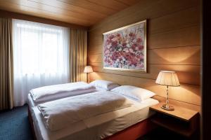 a hotel room with a bed and a desk at Residence Villa Stella in Ortisei