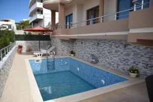 a swimming pool in front of a building at Guest House Evropa 2 in Ulcinj