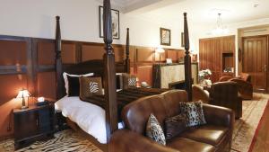 Hôtel particulier Le DOGE - Relais & Châteaux في الدار البيضاء: غرفة نوم بسرير وكرسي جلدي