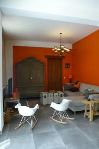 a living room with two white chairs and a couch at Gite du Domaine de la Maison Neuve in Saint-Jean-Saint-Germain