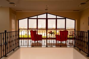 two red chairs on a balcony with a large window at Hotel Playa Sol by ALEGRIA in Puerto de Mazarrón