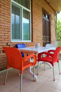 une table et des chaises assises sur une terrasse dans l'établissement Guest house Racha, à Ambrolaouri
