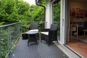 een patio met 3 stoelen en een tafel op een veranda bij Ferienappartement in der Spielestadt in Ravensburg