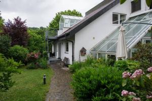 een wit huis met een patio en een tuin bij Ferienappartement in der Spielestadt in Ravensburg