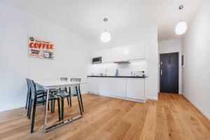 a kitchen and dining room with a table and chairs at VIU Apartament z tarasem w sercu Gdańska in Gdańsk
