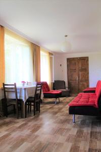 salon z czerwonymi meblami, stołem i krzesłami w obiekcie Guest house Racha w mieście Ambrolauri
