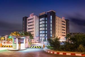 a hotel with tall buildings in a city at night at ibis Oran les Falaises in Oran