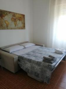 uma cama num quarto com um sofá em Casa Melissa em Savio di Ravenna