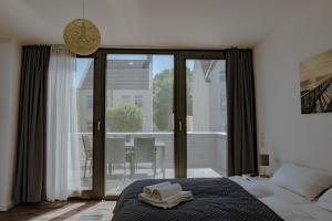 a bedroom with a bed and a large glass door at Meeresrauschen in Laboe