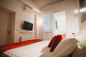 a bedroom with a bed and a tv on the wall at Hani Chrysomilou in Kalopanayiotis