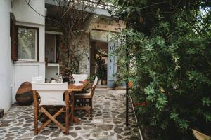 een patio met een tafel en stoelen op een stenen vloer bij Hani Chrysomilou in Kalopanayiotis