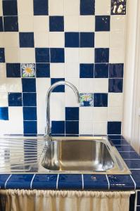 a sink in a kitchen with blue and white tiles at Ca Bossa Molina in Faggeto Lario 