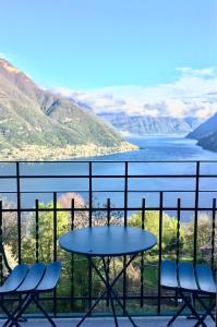 a table and chairs on a balcony overlooking the water at Ca Bossa Molina in Faggeto Lario 