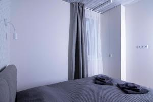 um quarto com uma cama com duas toalhas pretas em Poilsio Laboratorija 3B em Palanga