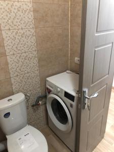 a bathroom with a toilet and a washing machine at Smaraldul Madalinei in Constanţa