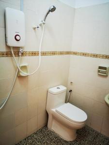 ein Bad mit einem WC und einer Dusche in der Unterkunft 12 pax Bidor Totoro House in Bidur