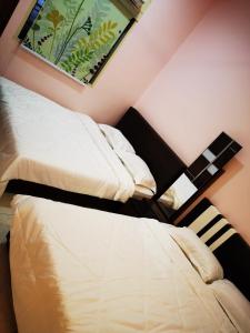 2 Betten nebeneinander in einem Zimmer in der Unterkunft 12 pax Bidor Totoro House in Bidur
