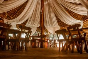 a dining room with tables and chairs under a tent at Pousada Recanto dos Milagres in São Miguel dos Milagres +33 photos