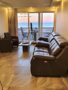 a living room with a couch and a view of the ocean at Cintra in Middelkerke