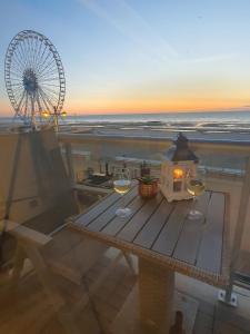 a table with two glasses of wine and a ferris wheel at Cintra in Middelkerke