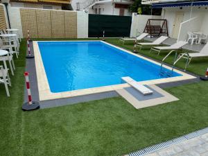 a large swimming pool with chairs and a table at Saint George Hotel in Asprovalta