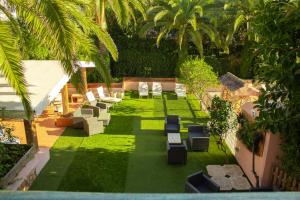 vistas panorámicas a un jardín con tumbonas y césped en Apartamentos Royal Life, en Mahón