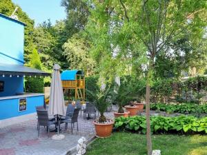 a patio with chairs and an umbrella and a playground at Vila Aqua in Eforie Sud