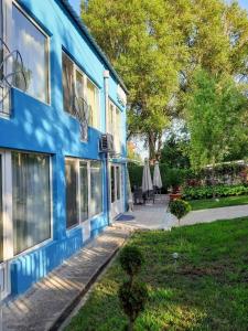 ein blaues Haus mit Bürgersteig neben einem Hof in der Unterkunft Vila Aqua in Eforie Sud