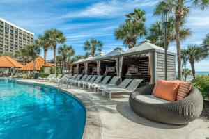 a resort swimming pool with lounge chairs next to a building at San Luis Resort Condos in Galveston