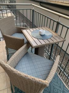 a wooden table and chairs on a balcony at Hamptons Apartment in Świnoujście