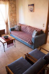 ein Wohnzimmer mit einem Sofa und einem Tisch in der Unterkunft Helen's Stone House in Siviri