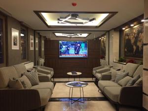 a living room with couches and a tv in a room at Kaya Life Resort in Uzungöl