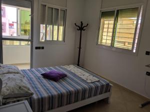 um quarto com uma cama com uma almofada roxa em Appartement Haron em Kenitra